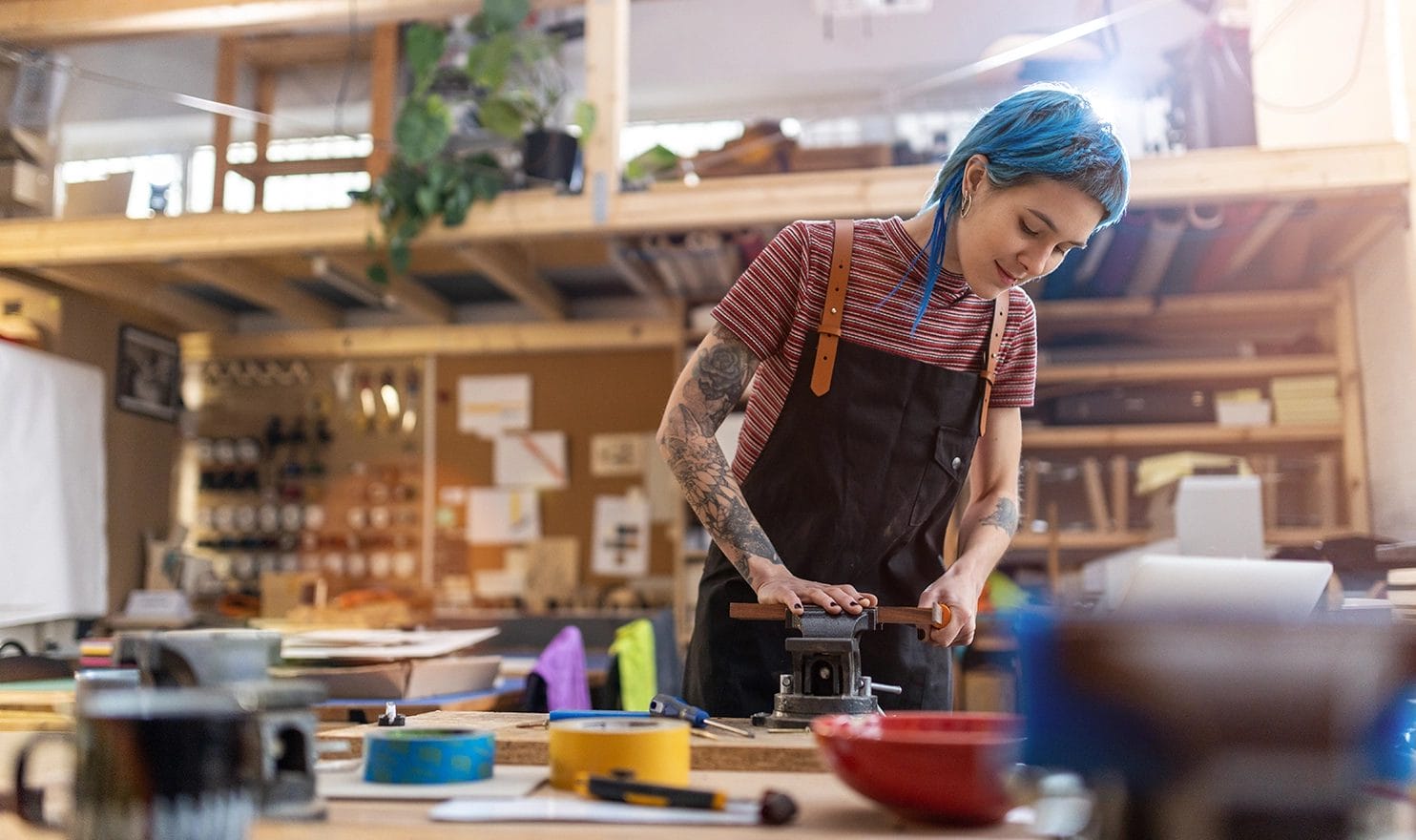 A painter is working on her latest piece, surrounded by her paints and tools in her studio.