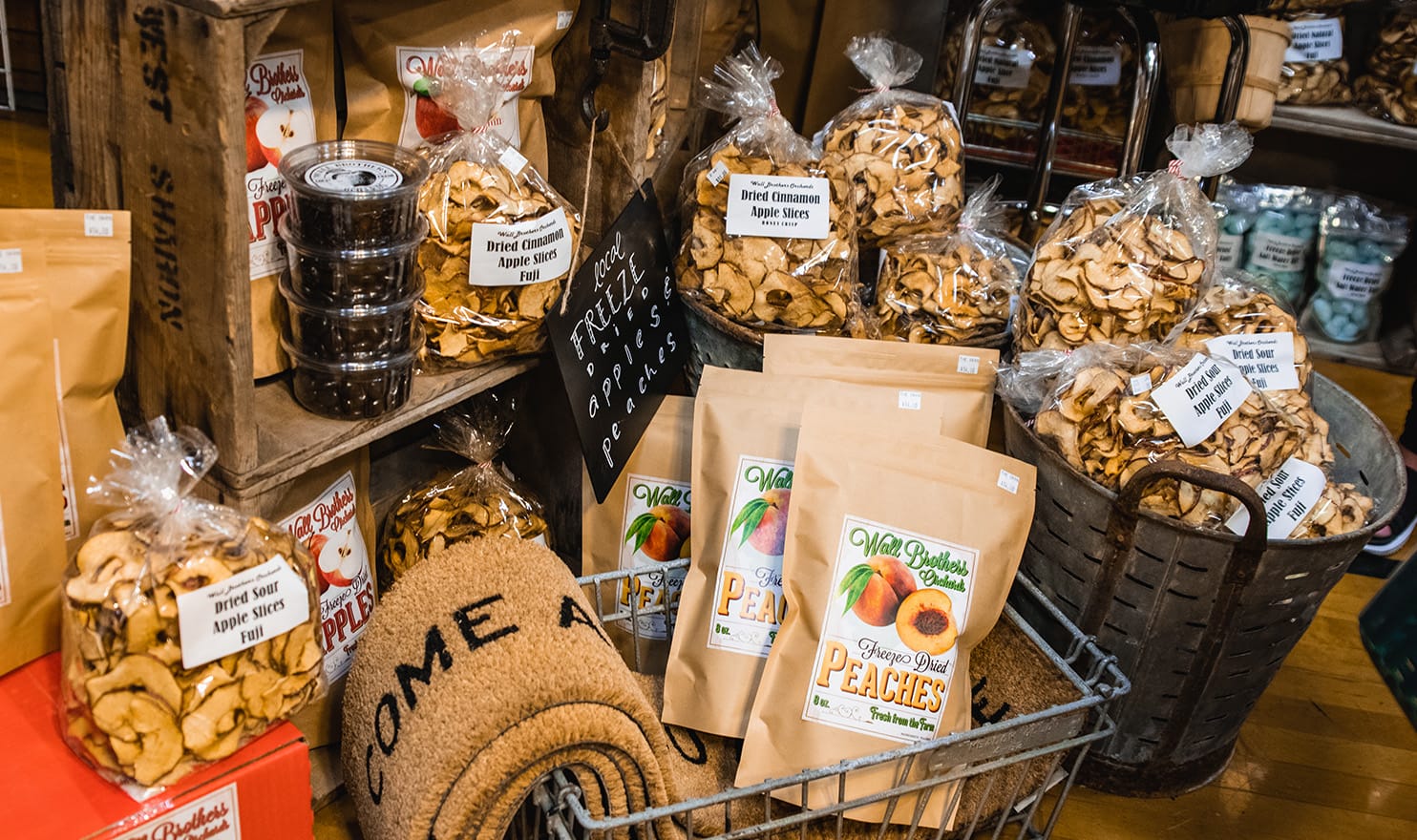 Dried apples, welcome mats, and other farm house decor sit on display in the Wall Brothers Orchards booth.