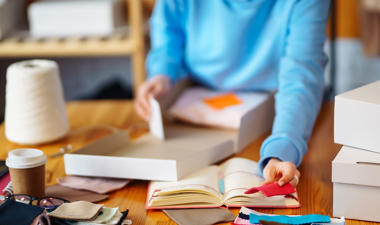 An artist is looking at different samples and products to create a catalog.