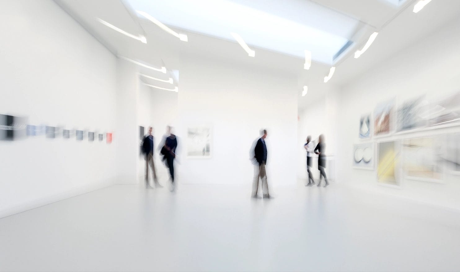 Blurry shot of people observing art in a gallery center.