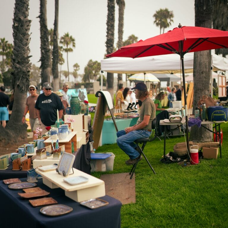 Vendor sitting at his paint and pottery booth