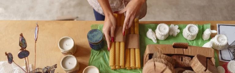 close up of a woman packing handmade candles for sale